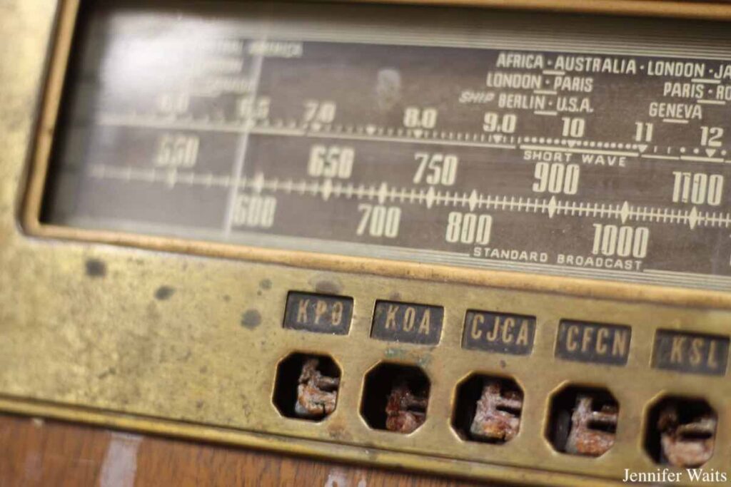 Photo of front of antique radio at campus and community radio station CJSR. Call letters for various stations are labeled on the radio, including KPO, KOA, CJCA, CFCN and KSL. Photo: J. Waits