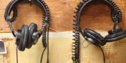 Podcast #343 – Catching up on College Radio and Podcasting News (March 19, 2025) photo of two pairs of headphones hanging on a wall at college radio station WRPI. Photo by J. Waits
